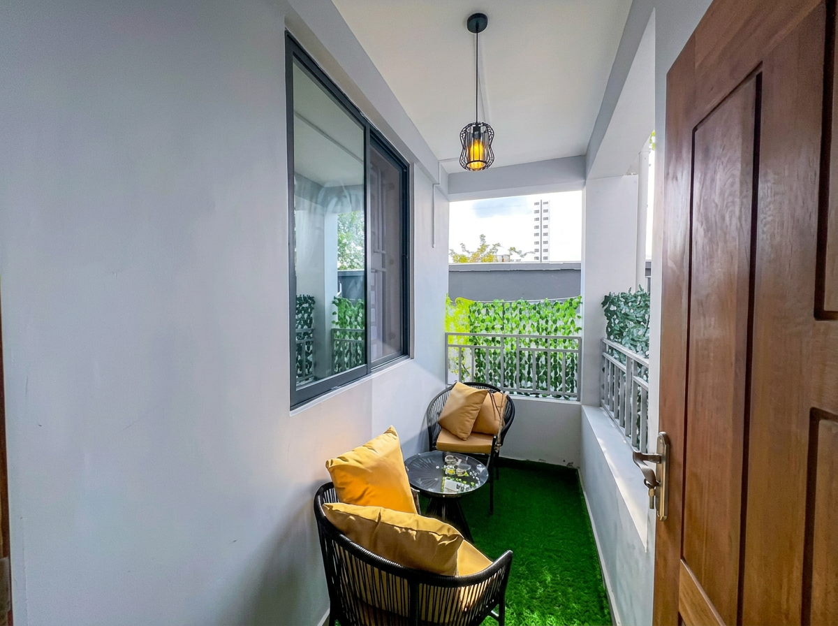 Private balcony with turf, chairs and yellow cushions